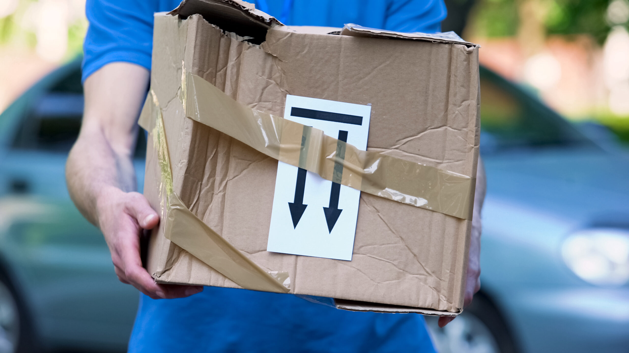 person holding a parcel that has been damaged in international shipping 